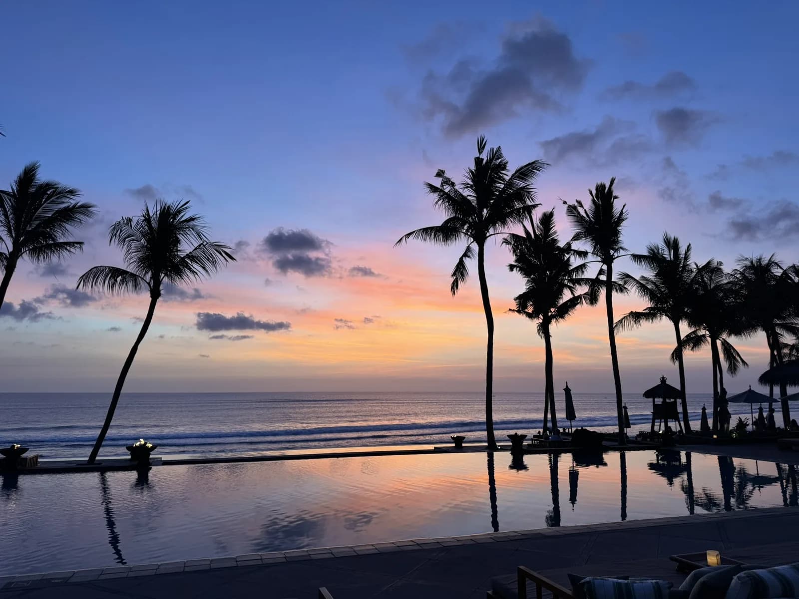 Sunset over the beach and infinity pool at The Legian Seminyak, Bali
